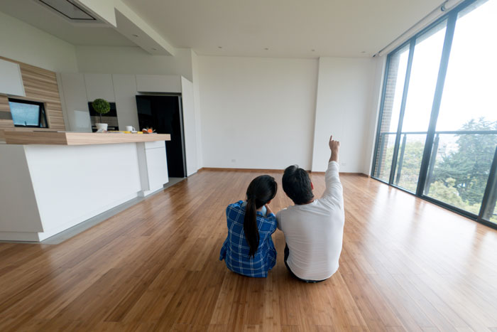 couple sitting on floor pointing at ceiling